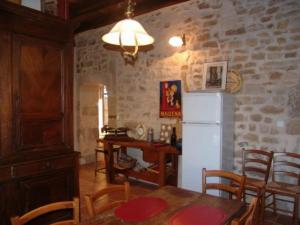 a kitchen with a table and a white refrigerator at Gîte Void-Vacon, 4 pièces, 6 personnes - FR-1-585-46 in Void