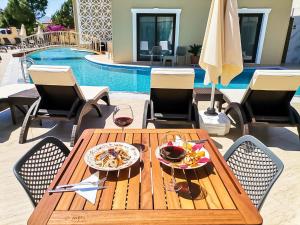 a wooden table with a plate of food and wine at Dna Hotel Dalyan in Dalyan