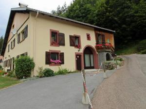 una casa con flores en las ventanas de un camino en Gîte Liézey, 2 pièces, 2 personnes - FR-1-589-211, en Liézey