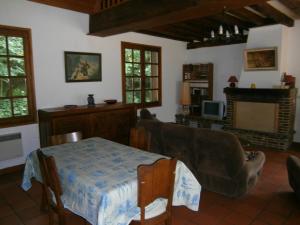 a living room with a table and a couch at Maison de charme en pleine nature avec étang de pêche, proche d'Authon-du-Perche, animaux admis. - FR-1-581-1 in Authon-du-Perche