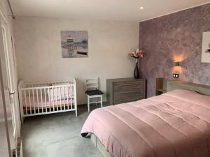 sypialnia z różowym łóżkiem i łóżeczkiem dziecięcym w obiekcie Gîte Fresse-sur-Moselle, 6 pièces, 12 personnes - FR-1-589-313 w mieście Fresse-sur-Moselle