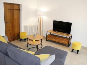 ein Wohnzimmer mit einem Sofa, einem TV und einem Tisch in der Unterkunft Gîte Les Herbiers, 4 pièces, 6 personnes - FR-1-426-432 in Les Herbiers