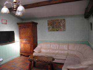 a living room with a white couch and a tv at Gîte Foussais-Payré, 7 pièces, 12 personnes - FR-1-426-121 in Payré-sur-Vendée