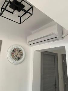 a ceiling fan and a clock on a wall at Overwave Apartment in Kavála