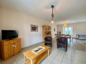 sala de estar con TV y mesa en Gîte Alleyrac, 4 pièces, 6 personnes - FR-1-582-66, en Alleyrac