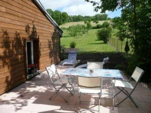 un patio avec une table et des chaises et un bâtiment dans l'établissement Gîte Velotte-et-Tatignécourt, 4 pièces, 6 personnes - FR-1-589-180, à Velotte-et-Tatignécourt