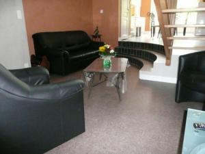 a living room with black leather furniture and a table at Gîte moderne avec billard et poêle à bois, proche de Mirecourt et Vittel, animaux bienvenus - FR-1-589-180 in Velotte-et-Tatignécourt +10 photos