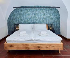 Una cama con dos almohadas blancas encima. en Pension Fortna, en Český Krumlov