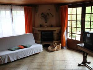 ein Wohnzimmer mit einer weißen Couch und einem Kamin in der Unterkunft Gîte La Saucelle, 4 pièces, 6 personnes - FR-1-581-57 