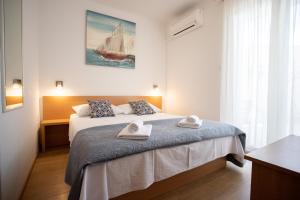 una camera da letto con un letto con due asciugamani sopra di Bol Studio Gospojica a Bol Altre 34 foto