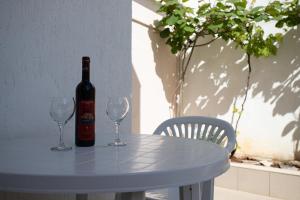 una bottiglia di vino seduta su un tavolo con due bicchieri da vino di Bol Studio Gospojica a Bol