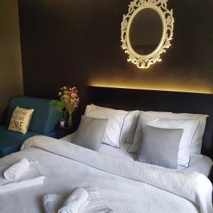 een slaapkamer met een wit bed en een spiegel bij Palicka Oaza 155 in Palić +27 foto's