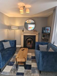a living room with two blue couches and a fireplace at AMY'S Place Charming 3 Bed House Donegal in Donegal