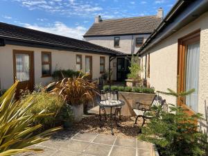 eine Terrasse mit einem Tisch und Stühlen vor einem Haus in der Unterkunft The Cross Guest House in Mablethorpe