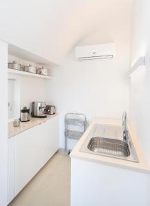 a kitchen with white cabinets and a sink at Lamia Alchimia in Selva di Fasano