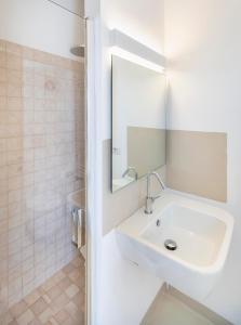 bagno bianco con lavandino e specchio di Lamia Alchimia a Selva di Fasano