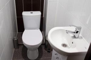 a bathroom with a white toilet and a sink at Belye Rosy in Belgorod