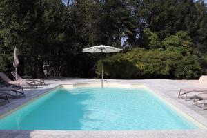 a swimming pool with an umbrella and two chairs at Villa Platamone in Como
