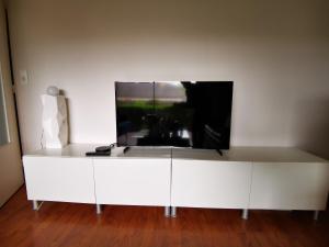 Biała szafka z telewizorem na górze w obiekcie Le grand briochin w mieście Saint-Brieuc