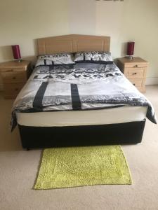 a bedroom with a bed with a rug and two night stands at Private room Bishop Norton in Bishop Norton