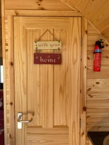 a wooden door with a home sign on it at North Point Pods NC500 in Thurso