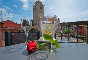 dwa kieliszki wina siedzące na stole z różą w obiekcie Hotel Corte Regina w Sirmione