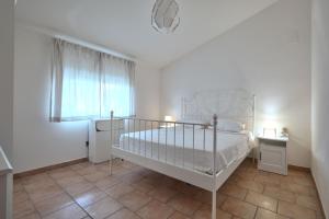 ein weißes Schlafzimmer mit einem Bett und einem Fenster in der Unterkunft Appartamento Zia Lucia in Terme Vigliatore