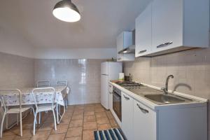 a kitchen with a sink and a table with chairs at Appartamento Zia Lucia in Terme Vigliatore