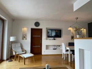 uma sala de estar com mesa e cadeiras e um relógio em Apartament Krystynka nr 1 em Poronin
