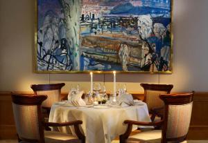 a table in a restaurant with a painting on the wall at Crystal Hotel superior in St. Moritz