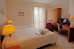Pokój hotelowy z łóżkiem i biurkiem w obiekcie Hotel Corte Regina w Sirmione