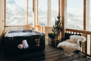een hot tub op een veranda met uitzicht op de bergen bij Lodji Hotel & spa in Saint-Martin-de-Belleville