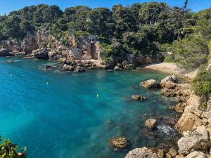 a view of a beach with blue water and rocks at Appartement 2 pièces au cœur du Cap d'Antibes in Antibes +8 photos