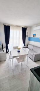 un soggiorno con un tavolo bianco e un divano di Appartamento Il Tramonto a Castelsardo