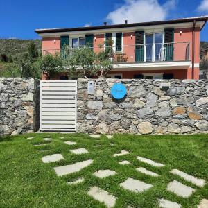 ein Haus mit einer Steinmauer und einem Zaun in der Unterkunft ARIA Design B&B Levanto in Levanto