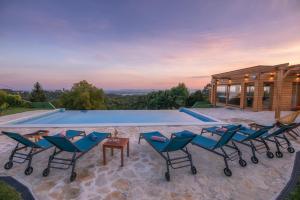 - un groupe de chaises assises à côté de la piscine dans l'établissement Gran Vista Holiday Home, à Gornji Mihaljevec