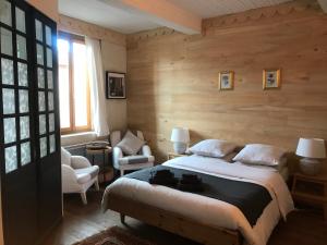 Un dormitorio con una cama grande en una habitación con paredes de madera. en Sûn Chambres d'hôtes, en Rabastens
