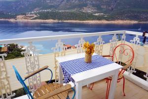 een tafel en stoelen op een balkon met uitzicht op het water bij Düşler Evim Butik Otel in Kas