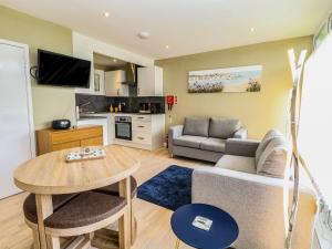 a living room with a couch and a table at Chalet 126a in Cromer