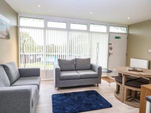 a living room with a couch and a table at Chalet 126a in Cromer