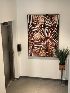 a painting hanging on a wall with a potted plant at Royal Flats in Las Palmas de Gran Canaria
