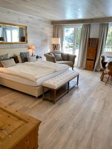 Hotel Europa St. Moritz في سان موريتز: غرفة نوم كبيرة مع سرير كبير وأريكة