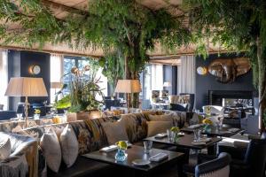 un ristorante con divani, tavoli e piante di La Réserve Genève Hotel & Spa a Ginevra