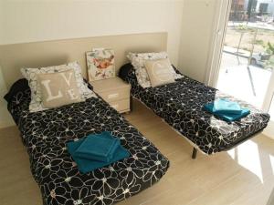 a small room with two beds and a window at los dos caballeros in San Pedro del Pinatar