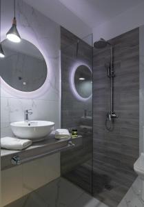 a bathroom with a sink and a glass shower at VagAthan - Lux Holidays in Afitos