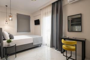 a bedroom with a bed and a table and yellow chairs at VagAthan - Lux Holidays in Afitos