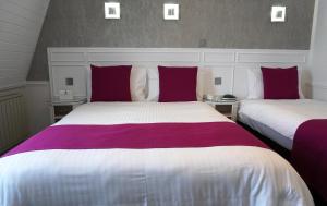 a hotel room with two beds and two lamps at Best Western Royal Hotel in Saint Helier Jersey