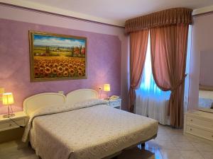 ein Schlafzimmer mit einem Bett und einem Wandgemälde in der Unterkunft Hotel La Torre in Castiglione del Lago