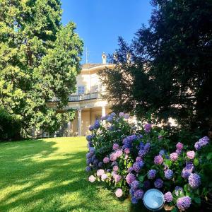 un giardino di fiori di fronte a una casa di Villa Platamone a Como