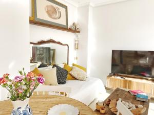 Playas de Vera的住宿－Sally del Mar - Nudist Naturist，一间卧室配有一张床和一张鲜花桌